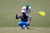 Brooks Koepka and caddie Ricky Elliott line up a putt on the second green during the third round of the 2016 Masters Tournament at Augusta National Golf Club.
