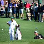 Hideki Matsuyama of Japan plays a shot from a bunker on the second hole as caddie Daisuke Shindo looks on during the first round of the 2016 Masters Tournament at Augusta National Golf Club.