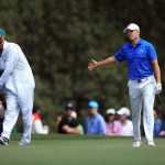 Jordan Spieth reacts to his shot on the first hole as caddie Michael Greller looks on during the final round of the 2016 Masters Tournament at Augusta National Golf Club.
