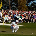 Danny Willett and caddie Jonathan Smart line up a putt on the 18th green during the final round of the 2016 Masters Tournament at Augusta National Golf Club.