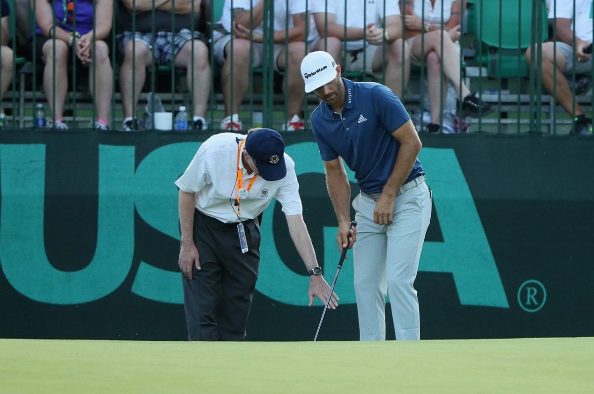 OAKMONT, PA - JUNE 19: Dustin Johnson of the United States chats with a rules official behind the 16th green during the final round of the U.S. Open at Oakmont Country Club on June 19, 2016 in Oakmont, Pennsylvania. (Photo by Andrew Redington/Getty Images)