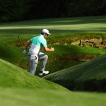 Jon Rahm climbs over the creek on 13 Thursday. (Rob Schumacher-USA TODAY Sports)