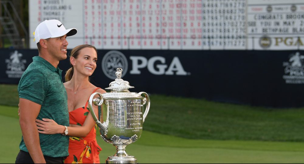 ST LOUIS, MO - AUGUST 12: Brooks Koepka of the United States poses with his girlfriend, Jena Sims, and the Wanamaker Trophy on the 18th green after winning the 2018 PGA Championship with a score of -16 at Bellerive Country Club on August 12, 2018 in St Louis, Missouri. (Photo by Ross Kinnaird/Getty Images)
