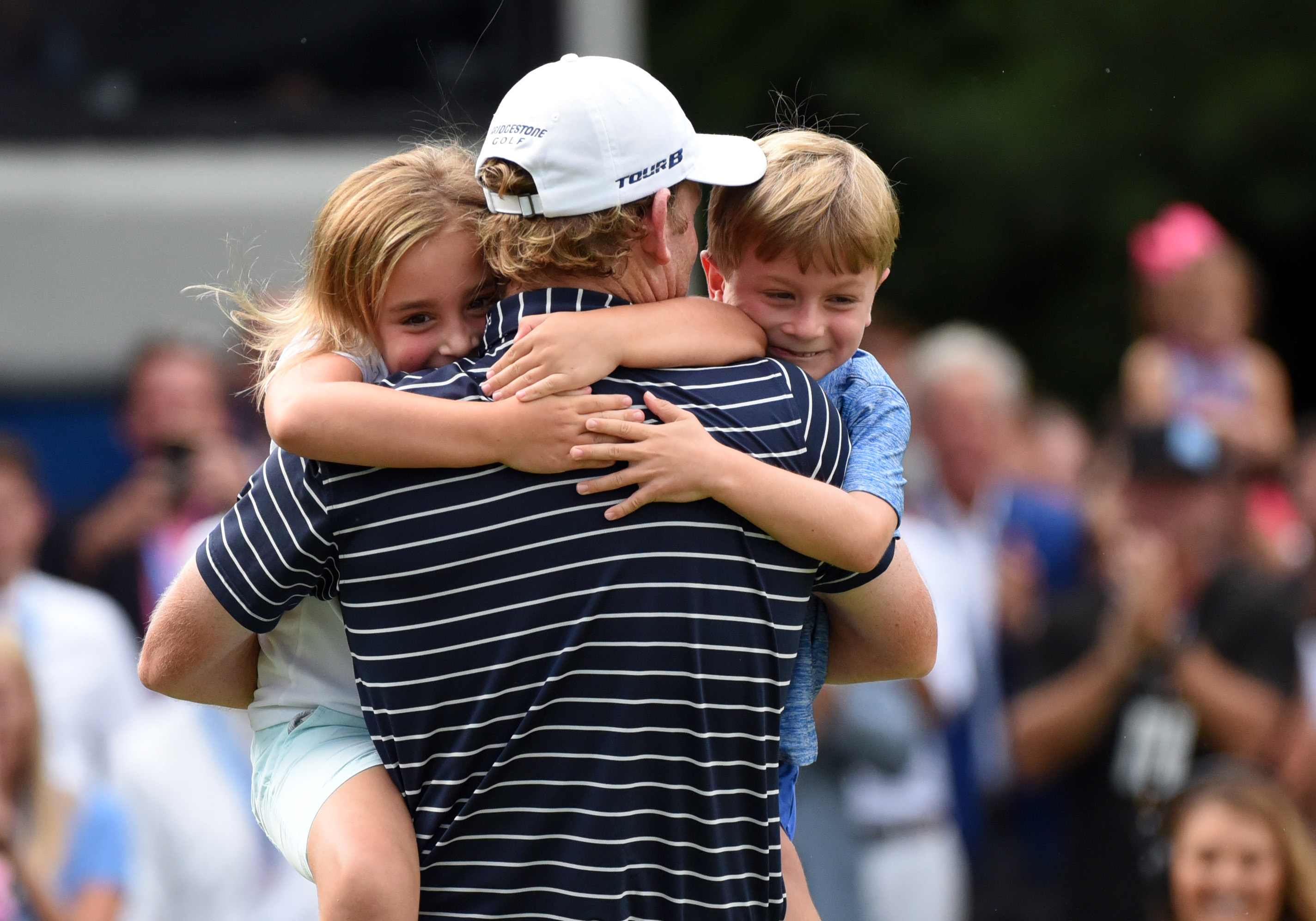 Aug 19, 2018; Greensboro, NC, USA; Brandt Snedeker is hugged by his children Lily (left) and Austin (right) after winning the Wyndham Championship golf tournament at Sedgefield Country Club. Mandatory Credit: Rob Kinnan-USA TODAY Sports