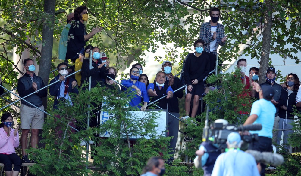 Patrick Reed tosses a ball to fans alongside the golf course fence line during the second round of the U.S. Open at Winged Foot Golf Club - West